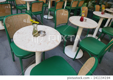 Bright cafe tables with green chairs in outdoor setting Bright cafe tables with green chairs in outdoor setting 141134194