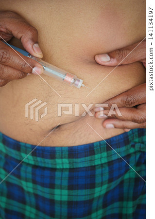 man making injection of insulin in his belly man making injection of insulin in his belly 141134197