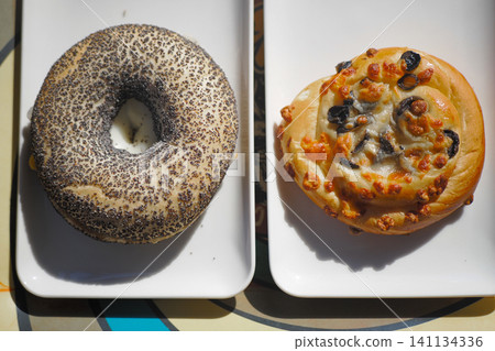 Two baked goods on white plates at a cafe table Two baked goods on white plates at a cafe table 141134336