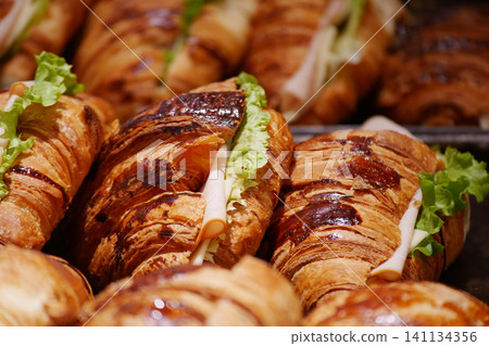 Fresh croissants filled with lettuce and ham in the bakery Fresh croissants filled with lettuce and ham in the bakery 141134356