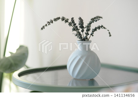 Lavender in a simple vase on a small table Lavender in a simple vase on a small table 141134656