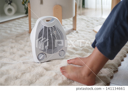 Warm air gently blows on feet during a cozy indoor moment Warm air gently blows on feet during a cozy indoor moment 141134661