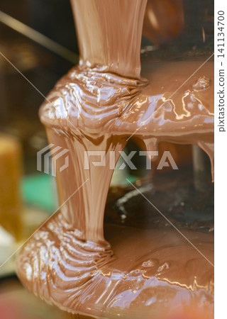 Chocolate flows from a fountain at a sweet event Chocolate flows from a fountain at a sweet event 141134700