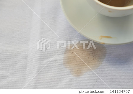 Coffee spill on a tablecloth during afternoon break Coffee spill on a tablecloth during afternoon break 141134707