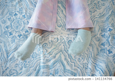 Relaxing at home with cozy socks and pastel pajama pants Relaxing at home with cozy socks and pastel pajama pants 141134766
