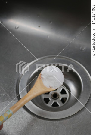 Baking soda on a wooden spoon near kitchen sink drain Baking soda on a wooden spoon near kitchen sink drain 141134805