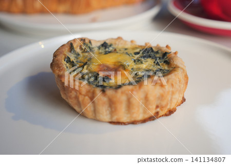 Fresh spinach tart sits on a white plate in a cafe Fresh spinach tart sits on a white plate in a cafe 141134807