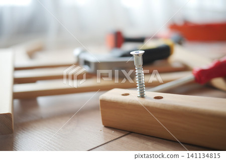 Tools and a screw arranged on a work surface 141134815