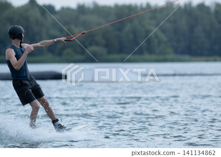 A man rides a wakeboard on a hot summer day. A man rides a wakeboard on a hot summer day. 141134862