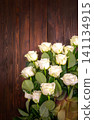 many white roses on a dark wooden background with a gift and a red bow, a mild day postcard, a Valentine's Day or a women's day. greeting card. place for text 141134915