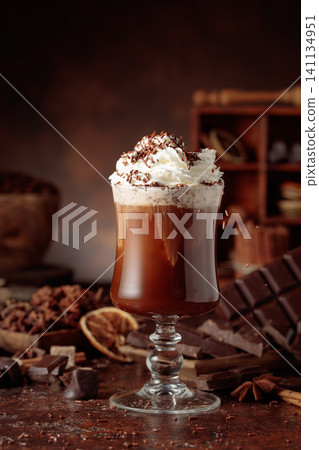Hot chocolate topped with whipped cream and sprinkled with chocolate chips. 141134951