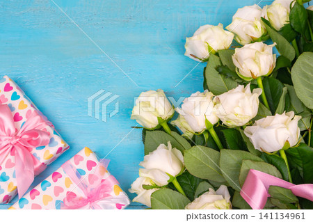 beautiful white roses on a blue wooden background. place for text. top view background beautiful white roses on a blue wooden background. place for text. top view background 141134961