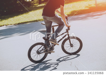 Bmx rider performing tricks at skatepark. 141135068
