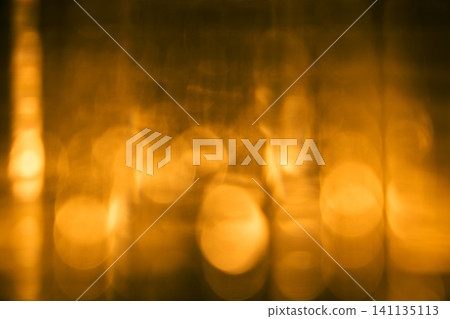 透過玻璃杯可以看到模糊的燭光，背景是抽象背景。 141135113