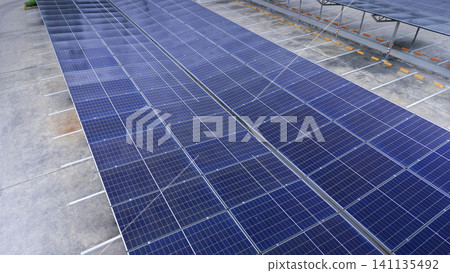 Solar roof. Aerial drone view of solar roof of carport or carpark. Photovoltaic panels covering a parking lot. Clean renewable energy infrastructure supports sustainable transportation. Solar energy Solar roof. Aerial drone view of solar roof of carport or carpark. Photovoltaic panels covering a parking lot. Clean renewable energy infrastructure supports sustainable transportation. Solar energy 141135492