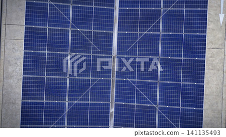 Solar roof. Aerial drone view of solar roof of carport or carpark. Photovoltaic panels covering a parking lot. Clean renewable energy infrastructure supports sustainable transportation. Solar energy Solar roof. Aerial drone view of solar roof of carport or carpark. Photovoltaic panels covering a parking lot. Clean renewable energy infrastructure supports sustainable transportation. Solar energy 141135493