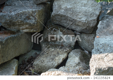Pile of rough cut natural stone blocks with moss, close-up texture Pile of rough cut natural stone blocks with moss, close-up texture 141135824