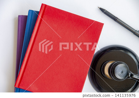 Colored law book with a judges gavel on a clean white background with customizable space for text 141135976