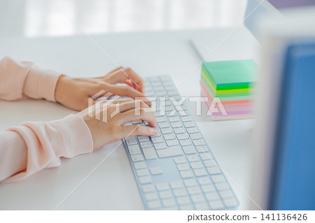 Young woman's hand operating a personal computer Young woman's hand operating a personal computer 141136426