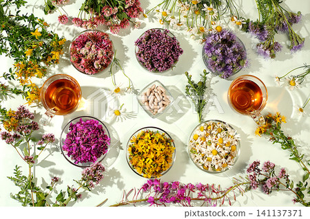 Medicinal herbs and their flower petals in glass cups for infusions or tea, concept of alternative folk medicine, advertisement of a green pharmacy, collection of useful herbs for treatment according Medicinal herbs and their flower petals in glass cups for infusions or tea, concept of alternative folk medicine, advertisement of a green pharmacy, collection of useful herbs for treatment according 141137371