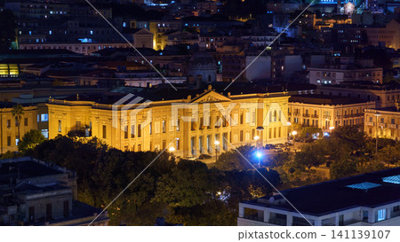MESSINA, ITALY - NOVEMBER 06, 2018 - Panoramic top night view of the local buildings with lights, mountains in the beautiful city of Sicily MESSINA, ITALY - NOVEMBER 06, 2018 - Panoramic top night view of the local buildings with lights, mountains in the beautiful city of Sicily 141139107