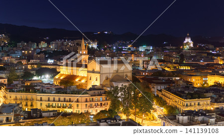 Panoramic top night view of the local buildings with lights, mountains in the beautiful city of Messina, Sicily, Italy 141139108