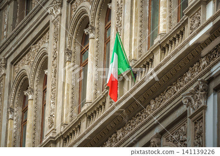 Naples, Italy - Nov 5 2018, Panoramic view of the Neo-Renaissance facade with the Italian flag flattering on the flagpole, in the Galleria Umberto I, without people, Naples, Italy Naples, Italy - Nov 5 2018, Panoramic view of the Neo-Renaissance facade with the Italian flag flattering on the flagpole, in the Galleria Umberto I, without people, Naples, Italy 141139226