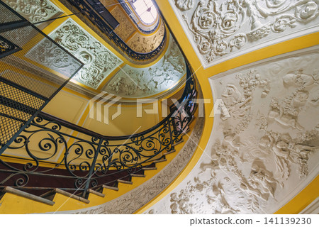 Naples, Italy - November 5, 2018, Panoramic view of antique curved staircase decorated with stucco with wrought iron railings with a floral pattern at Galleria Umberto I, without people, Naples, Italy 141139230