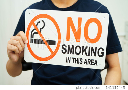 Male holding a no smoking sign. 141139445