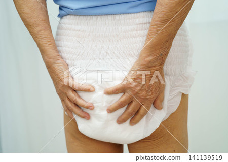 Asian senior woman patient wearing adult incontinence diaper pad in hospital. Asian senior woman patient wearing adult incontinence diaper pad in hospital. 141139519