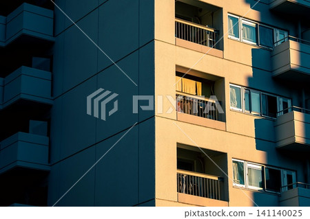 The exterior of a Japanese apartment building illuminated by the soft evening light. The exterior of a Japanese apartment building illuminated by the soft evening light. 141140025