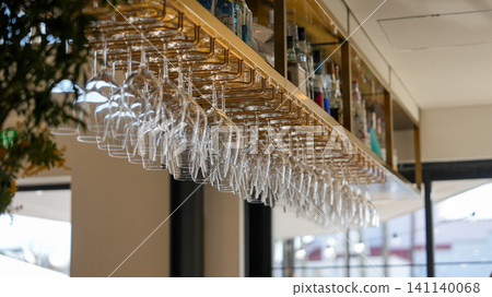 Wine glasses hanging above the bar counter in a restaurant Wine glasses hanging above the bar counter in a restaurant 141140068