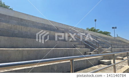 Empty Concrete Stadium Bleachers Under Clear Blue Sky Empty Concrete Stadium Bleachers Under Clear Blue Sky 141140784