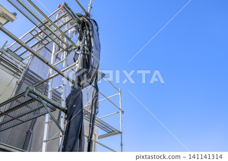 A house after exterior wall renovation and temporary scaffolding for roof work. A house after exterior wall renovation and temporary scaffolding for roof work. 141141314