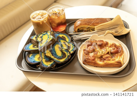 在時尚的韓國咖啡館裡,享用色彩繽紛的丹麥酥餅和冰咖啡。 在時尚的韓國咖啡館裡,享用色彩繽紛的丹麥酥餅和冰咖啡。 141141721