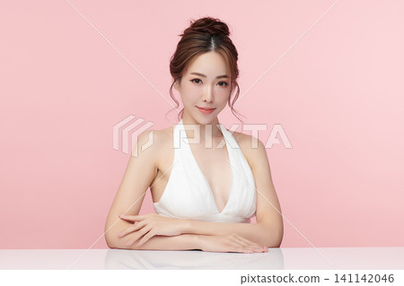 A beautiful young Asian woman with clean, fresh skin against a pink background. Skincare, facial treatment, cosmetology, beauty, and spa. An elegant portrait of an Asian woman. A beautiful young Asian woman with clean, fresh skin against a pink background. Skincare, facial treatment, cosmetology, beauty, and spa. An elegant portrait of an Asian woman. 141142046