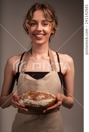 Woman smiling, holding fresh sourdough bread, a symbol of healthy artisan baking and culinary passion Woman smiling, holding fresh sourdough bread, a symbol of healthy artisan baking and culinary passion 141142681