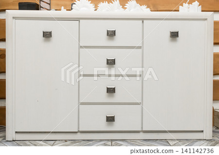 White wooden interior design detail with chest of drawers White wooden interior design detail with chest of drawers 141142736