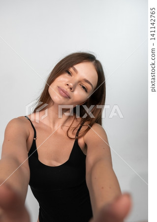 Young woman reaching out, smiling and connecting, capturing a moment with personal perspective on white background Young woman reaching out, smiling and connecting, capturing a moment with personal perspective on white background 141142765