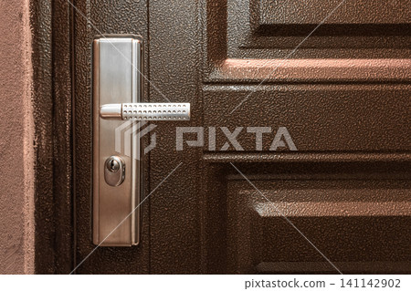 Steel doorknob brown wooden opening closing entrance exit house home object close-up Steel doorknob brown wooden opening closing entrance exit house home object close-up 141142902