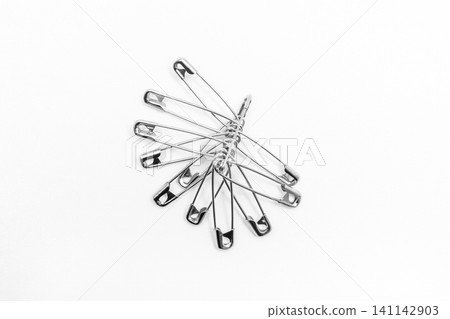 Pins or paper clips to remind you of objects on a white background Pins or paper clips to remind you of objects on a white background 141142903