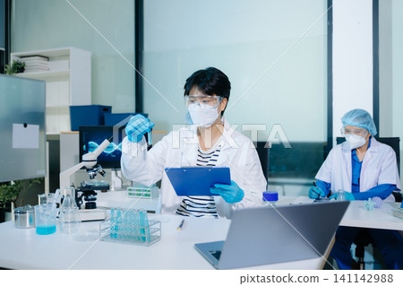 A professional uses biometric fingerprint scanning on a digital tablet in a high-tech lab, representing secure data access and innovation in biotechnology 141142988