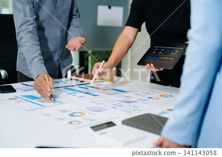 Business documents on office table with smart phone and calculator digital tablet and graph business with social network diagram and two colleagues discussing data working 141143058