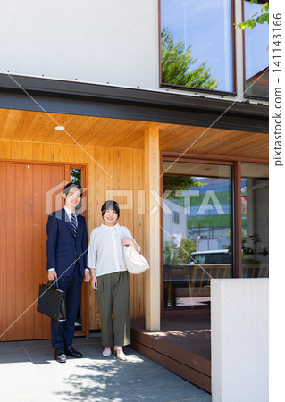 A young couple stands in front of their new home. A young couple stands in front of their new home. 141143166