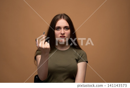 Young woman showing middle finger gesture, expressing anger and disapproval with a defiant facial expression Young woman showing middle finger gesture, expressing anger and disapproval with a defiant facial expression 141143573