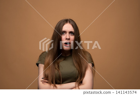 Young woman gasping in disbelief, feeling shocked and surprised, expressing astonishment with wide eyes and open mouth 141143574