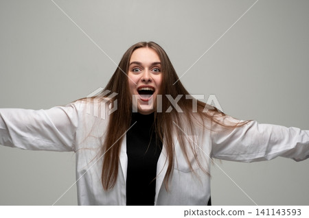 Young woman showing excitement and surprise with wide eyes and open mouth, expressing happiness and shock Young woman showing excitement and surprise with wide eyes and open mouth, expressing happiness and shock 141143593