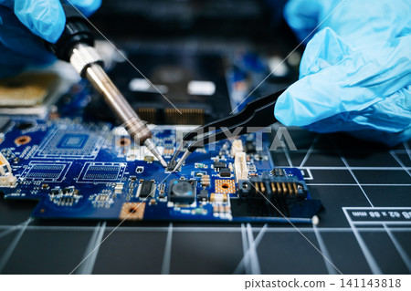 technician soldering microchip on circuit board, highlighting precision electronics repair, hardware maintenance, and advanced technology work. technician soldering microchip on circuit board, highlighting precision electronics repair, hardware maintenance, and advanced technology work. 141143818