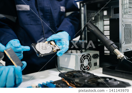 Technicians repairing computer hardware, testing components and upgrading PC systems. Technology service, electronics engineering and IT support concept. 141143970