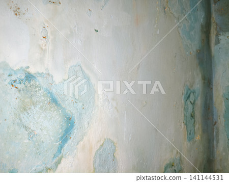 Abstract background of a weathered and distressed wall with peeling paint and plaster in faded light blue and beige tones, showcasing aged texture and grunge details. Abstract background of a weathered and distressed wall with peeling paint and plaster in faded light blue and beige tones, showcasing aged texture and grunge details. 141144531
